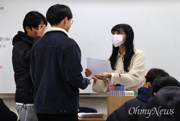 8일 오전 서울 종로구 경복고등학교 3학년 교실에서 교사가 수능성적표를 배부하고 있다.