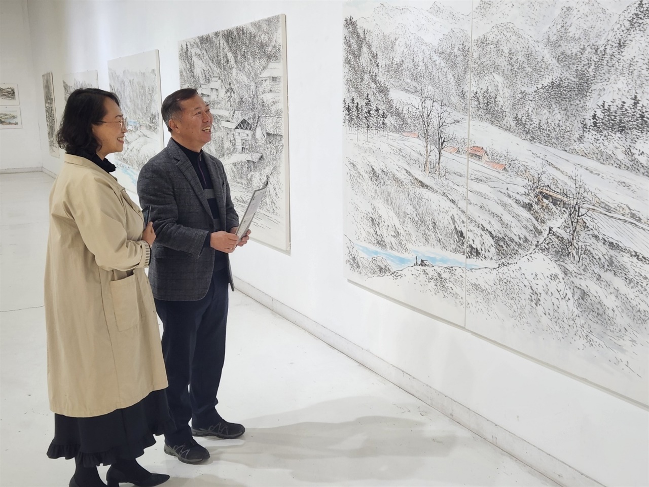 겨울날 고요한 농촌마을의 풍경을 그렸다고 설명하는 김승호 화백 
