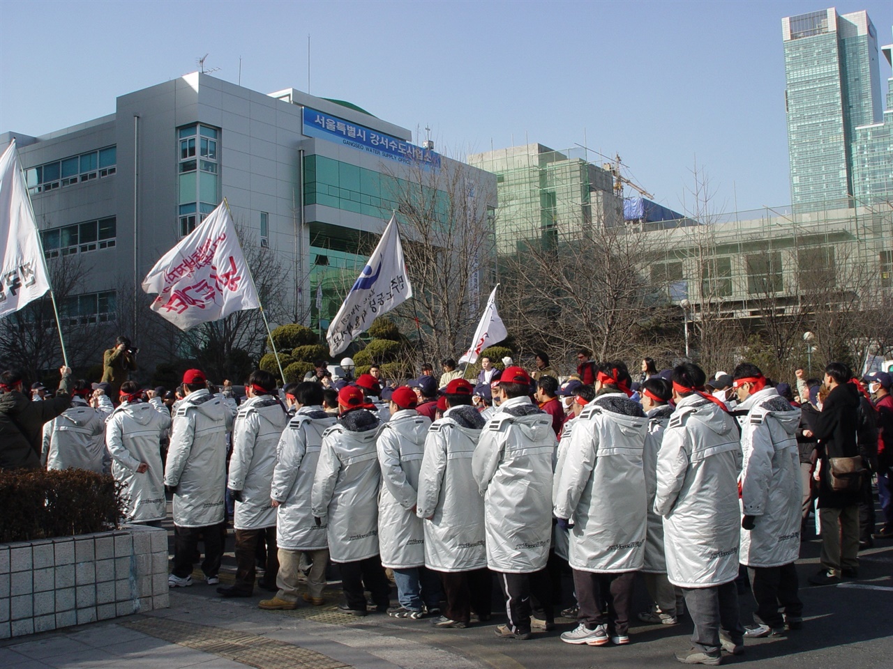  서울출입국관리소 앞에서 보호소 내 단식투쟁 돌입 선포식 및 항의 집회가 열렸다. (2004.02.17.) 당시 파업을 진행 중이었던 외환카드 노동조합이 함께 했다. ‘사장님’, ‘사모님’이라고 부르는 사람밖에 없었던 이주노동자들에게 이제는 연대하는 ‘동지’가 생겼다. 새로운 관계의 시작이었다.