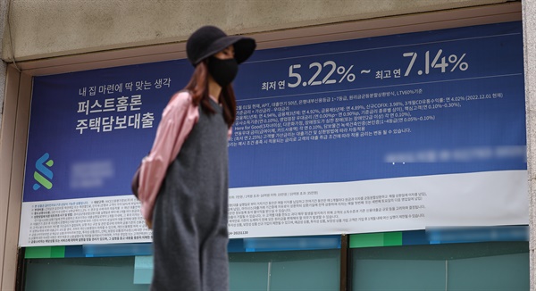 2022년 우리나라 GDP 대비 가계부채 비율이 108.1%를 기록했다는 IMF 자료가 발표된 10월 3일 서울 시내 은행에 붙은 대출 관련 현수막 앞을 한 시민이 지나고 있다.