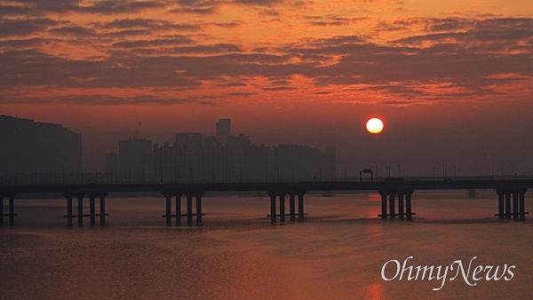 2024년 1월 1일 첫 일출. 서울 하늘 짙게 깔린 구름 위로 태양이 떠오르고 있다. 서강대교 위에서 바라본 장면.