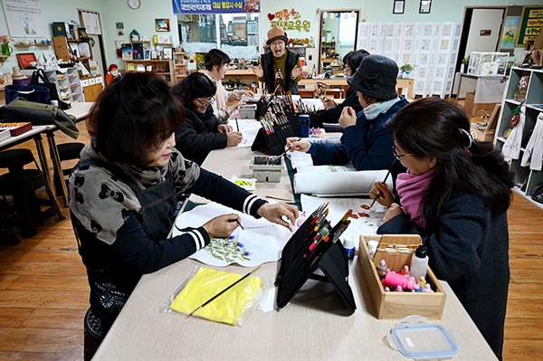  맞춤평생교육원 정재숙 원장이 오색라인 회원들에게 천 아트에 대한 설명하고 있다.