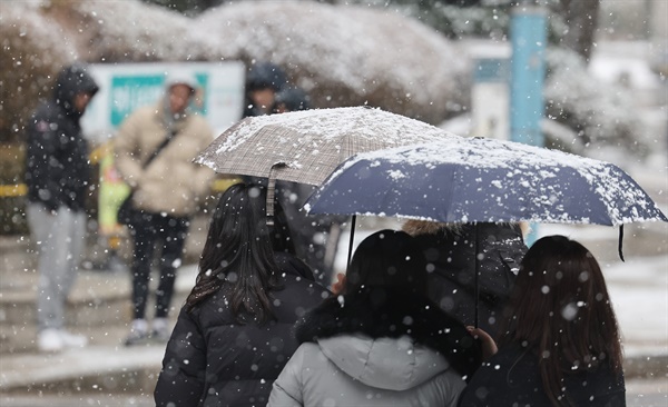 눈이 내린 17일 오후 우산을 쓴 시민들이 서울 종로구 한 거리를 지나고 있다. 