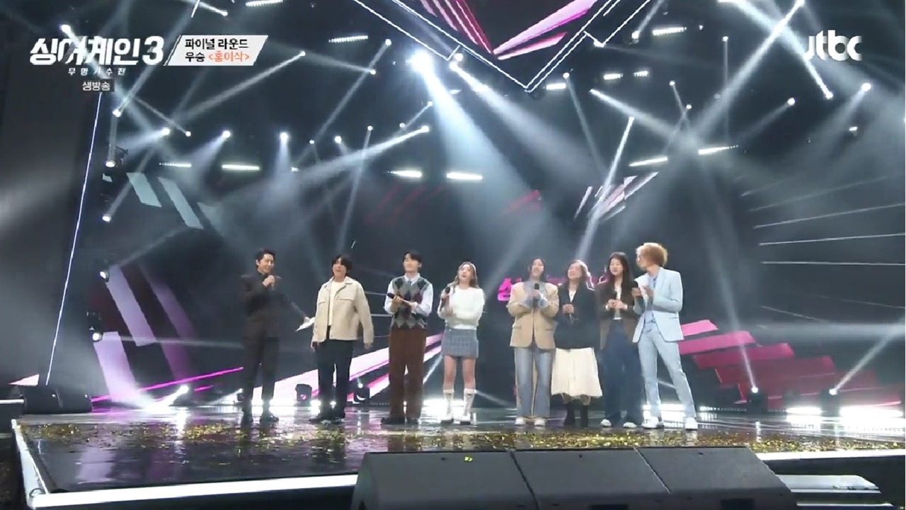 가수 홍이삭이 <싱어게인3> 우승자로 선정돼, 동료 가수들이 축하를 건네고 있다.