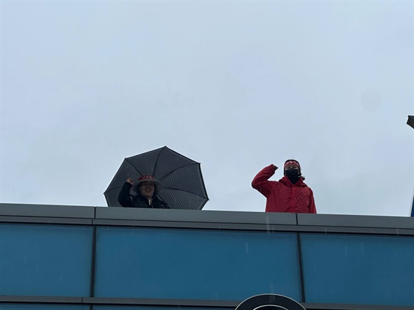 비오는 날 공장 옥상에서 투쟁을 외치고 있는 소현숙조직2부장(왼쪽)과 박정혜수석부지회장(오른쪽)