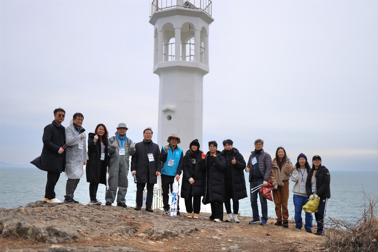 설맞이 어촌돕기에서 돌산 큰끝등대에서 한국해양재단 문해남 이사장(좌측에서 다섯번째) 회원들이 해양정화활동을 펼친후 한컷

