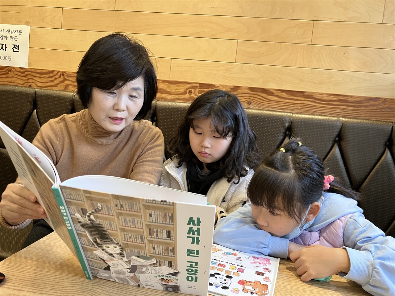 / 서안메밀 상동점 김효순 대표가 아이들과 그림책을 연주하고 있다