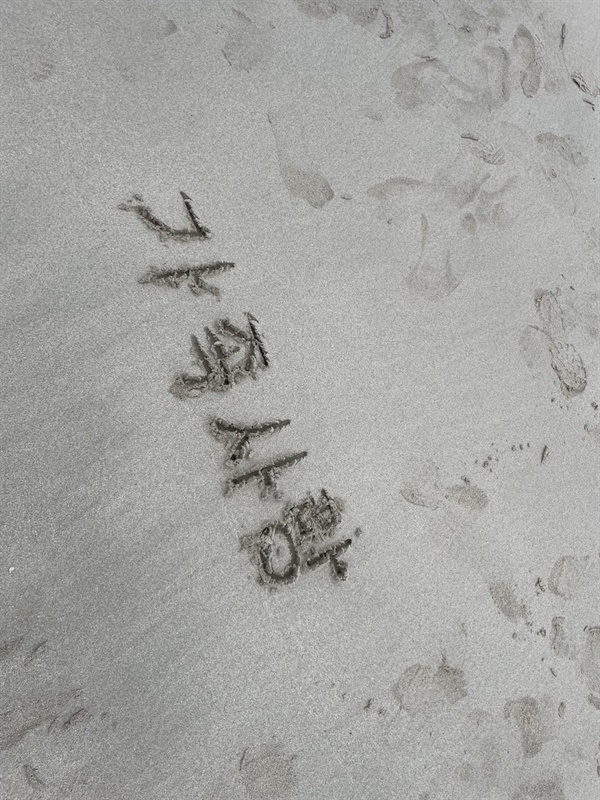 남편이 모래 사장에 쓴 글씨