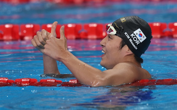  김우민이 2024년 2월 11일 카타르 도하에서 열린 2024 FINA 세계수영선수권대회 남자 자유형 400m 결승에서 우승한 후 환호하고 있다.