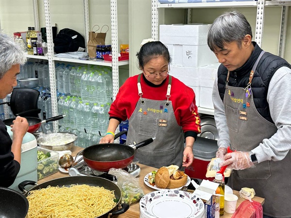 옵티칼 후원주점에서 김주휘씨(빨간 상의)와 우리밥연대 활동가들이 음식을 준비하고 있다.
