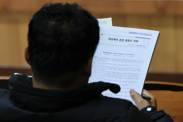 19일 오전 서울 중구 성동공업고등학교에서 열린 학교폭력 전담 조사관 역량강화 연수 개회식에서 한 조사관이 안내 책자를 읽고 있다.

