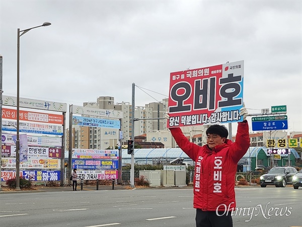 대구 동구을 선거구에 출마한 오비호 국민의힘 예비후보가 거리에서 피켓을 들고 선거운동을 하고 있다.
