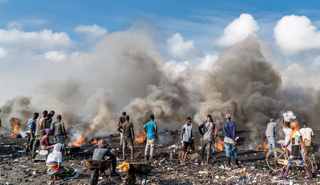 가나의 수도 아크라의 아그보그블로시 지역의 쓰레기처리장에서 구리를 회수하기 위해 전선을 태우는 젊은이들  