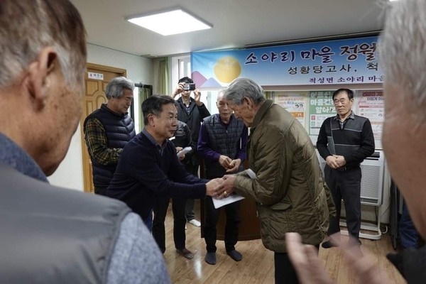 윤영석(왼쪽) 이장이 이수복 어르신에게 마을표 경로수당을 전달했다 