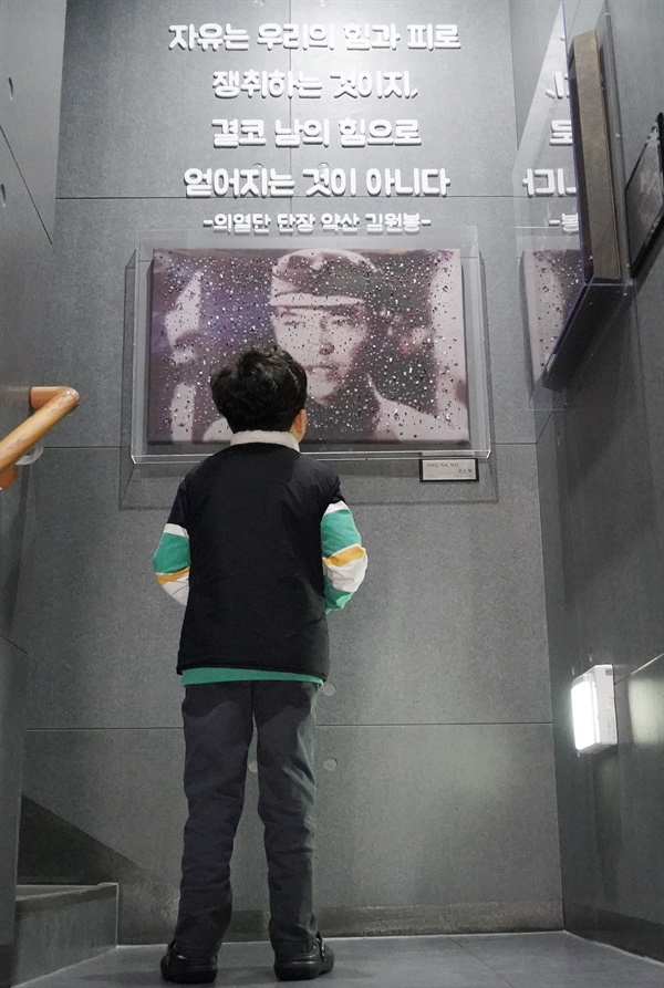 한 어린이가 의열단장 김원봉의 사진을 보고 있다. 