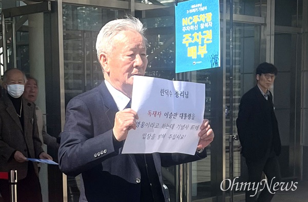 박홍기 경남민주화운동동지회장이 15일 오전 창원마산 3.15아트센터 앞에서 손팻말을 들고 서 있다.