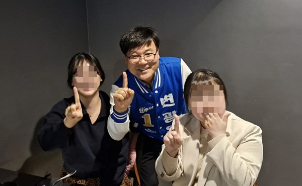 변광용 민주당 후보(사진 가운데)가 식당에서 만난 손님들과 손가락으로 숫자 1을 표시하며 사진 촬영을 하고 있다. 