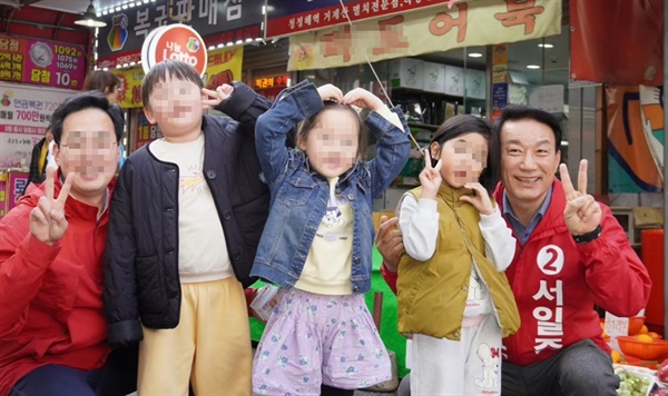 서일준 국민의힘 후보가 시장에서 어린이와 함께 촬영을 하고 있다(맨 오른쪽).