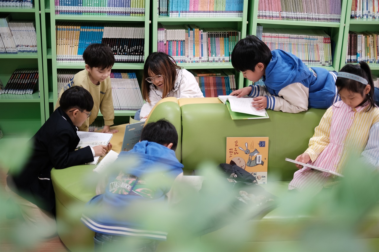 이원초로 농촌 유학 온 삼둥이들이 친구들과 도서실에서 책을 읽고 있다.