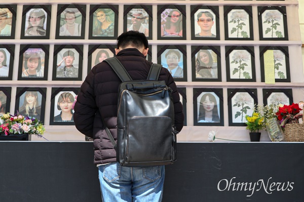 지난 14일 서울 중구 서울광장에 마련된 이태원 참사 시민분향소를 찾은 한 추모객이 희생자들의 영정 앞에서 묵념을 올리고 있다.