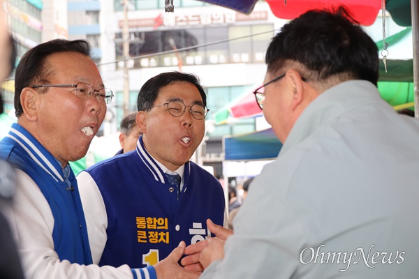 24일 창원 상남시장을 찾은 김부겸 더불어민주당 선거대책위원장과 허성무 후보가 한 상인이 주는 강정을 받아먹고 있다.