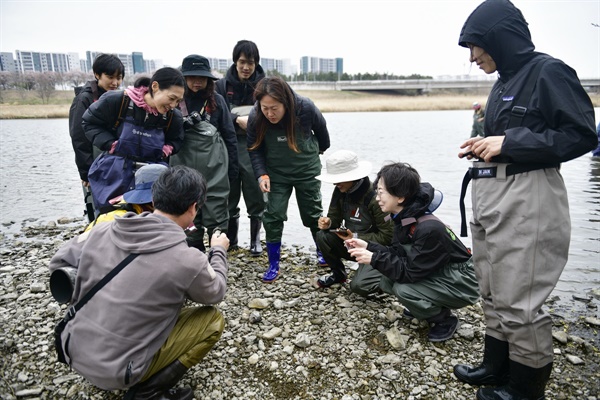팔현습지 현장조사에 참여한 시민과학자들이 팔현습지 하천변에서 발견된 수달똥을 이리저리 살펴보고 있다. 