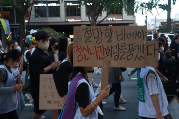 "절망할 바에야 정신나간 희망을 품겠다"라고 적힌 피켓을 들고 행진하는 924 기후정의행진 참여자