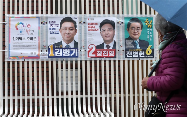 29일 오전 제22대 국회의원 선거 서울 동작구갑 지역에 출마한 후보자들의 선거벽보 앞으로 한 유권자가 지나가고 있다.