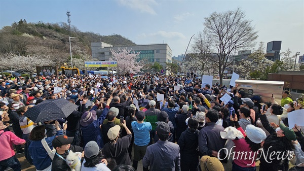 3월 30일 광주광역시 서구 풍암호수에서 시민들과 지지자들이 조국혁신당 조국 대표가 기자회견 하는 모습을 지켜보고 있다.
