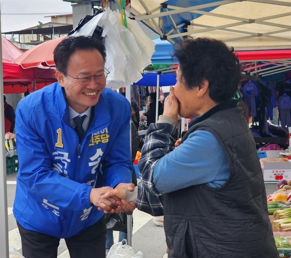 충북 청원 내수읍 장날 장터에서 송재봉 민주당 후보가 주민들과 인사하고 있다.
