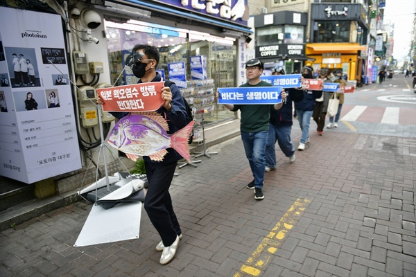 물고기 탈을 쓰고 피켓을 든 채 함께 외치면서 행진하고 있는 '일본 핵오염수 해양투기 저지 대구시민공동행동' 단원들.