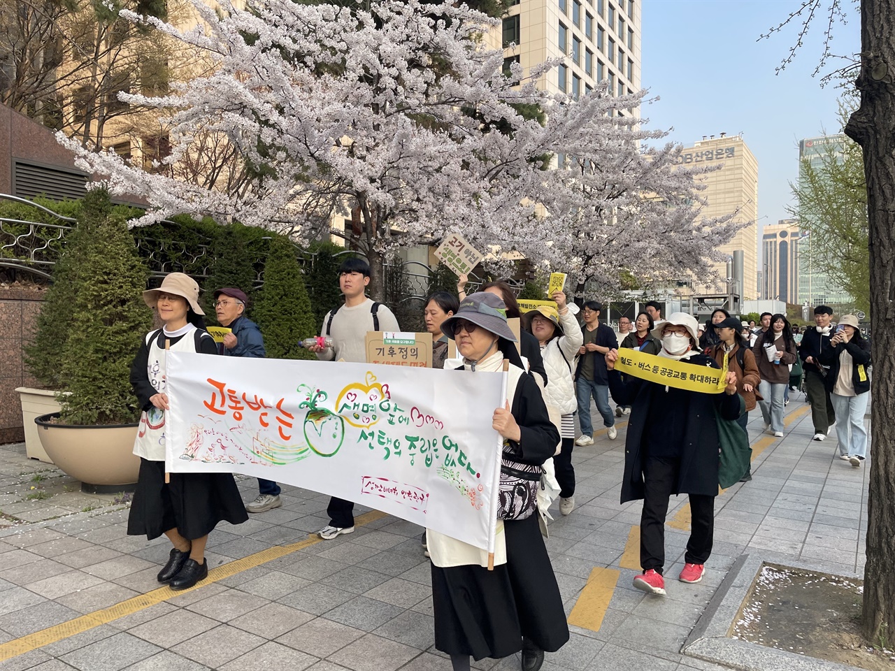 기후시민열린광장 참가자들이 ‘고통받는 생명 앞에 선택의 중립은 없다’ 등이 적힌 펼침막과 손팻말을 들고 서울 여의도 거리를 행진하고 있다.