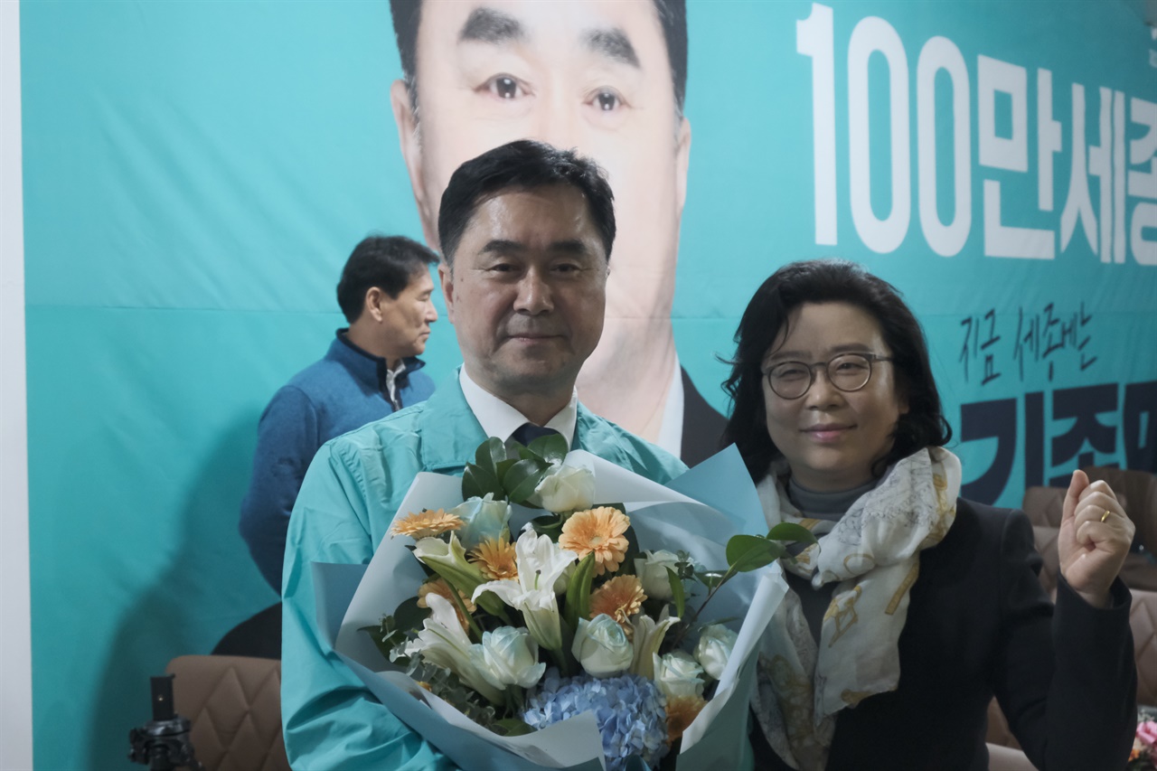 김종민 새로운미래 후보자가 11일 자정께 당선이 확실시 되자 지지자로부터 꽃다발을 받고 함께 기념촬영을 하고 있다.