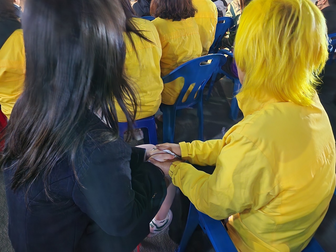 최지영씨가 핫팩을 쥔 손으로 최예은 학생의 손을 감싸고 있다. 