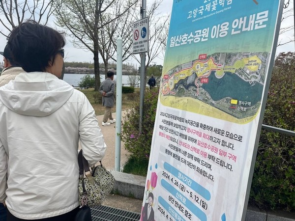 주민들이 호수공원 산책로 제한 안내문을 보고 있다.

