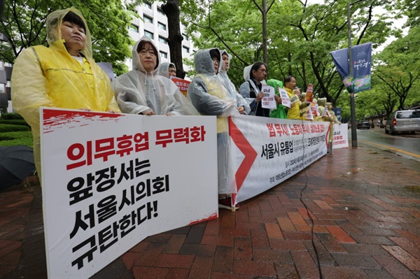 서울시의회의 의무휴업을 무력화하는 조례에 반대하며 항의 피켓을 들고 있다.