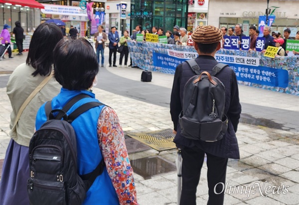 24일 정오, 시민단체가 경기도 군포 산본 중심상가에서 개최한 ‘반전 자주 평화연대 선언식을 지켜보는 행인들