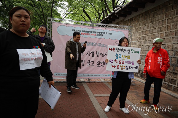 24일 오후 서울시의회 의원회관 앞 서울피플퍼스트 주최로 열린 '장애인 탈시설 지원조례 폐지를 막기 위한 24시간 공동행동'에서 탈시설 발달장애인들이 무대로 나와 춤추며 노래하고 있다.