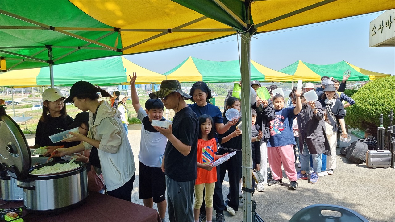 지난 27일 충남 홍성읍 소세울 마을 꽃무릇 심기 축제현장. 시민들이 용기(그릇)로 밥을 덜어 먹고 있다. 