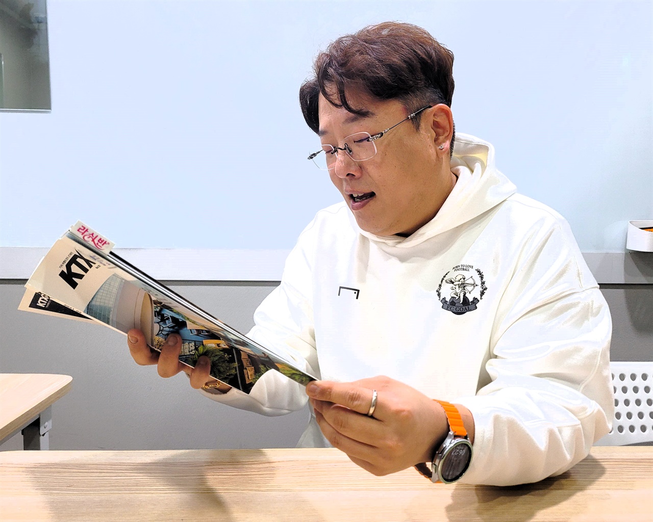 14년째 KTX 안내방송을 담당하고 있는 고구인 성우가 서울 양재동에 위치한 자신의 학원에서 KTX 매거진을 읽어보고 있다.