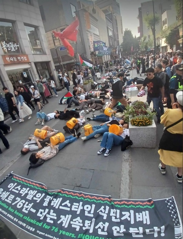 4일 '팔레스타인 연대' 집회 후 행진에서 참가자들이 인사동 거리에서 3분여 간 도로 바닥에 죽은 듯이 눕는 '다이인(Die-In) 시위'를 하고 있다. 