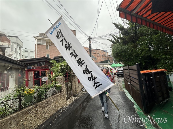  6일 오전 10시 30분께 서울 종로구 대학로 백기완마당집 앞 개관식서 '백기완 집 문 열었소'라고 적힌 만장을 들고 가는 김주환 민주노총 서비스연맹 전국대리운전노동조합 위원장.