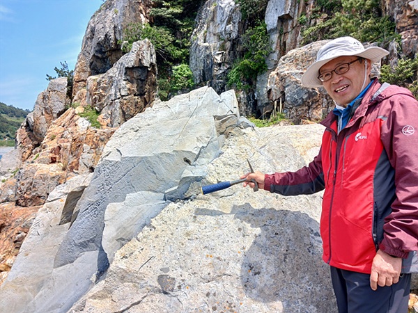 국가지질공원 전문위원인 박정웅 박사가 정월래굴 인근에 떨어진 바위에 대해 설명하고 있다. 하나로 붙어있지만 완연히 색깔이 다른 이유는 화산쇄설암에 안산암이 뜷고 들어갔다고 한다.  