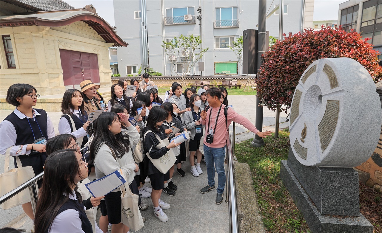 5월 7일 '목포 오월길' 걷기에 참가한 목포여중 학생들이 목포중앙교회 옛터에 세워진 5.18사적지 표지석 앞에서 해설사의 설명을 듣고 있다. 박지원 학생이 해설사 바로 앞에 서 있다.