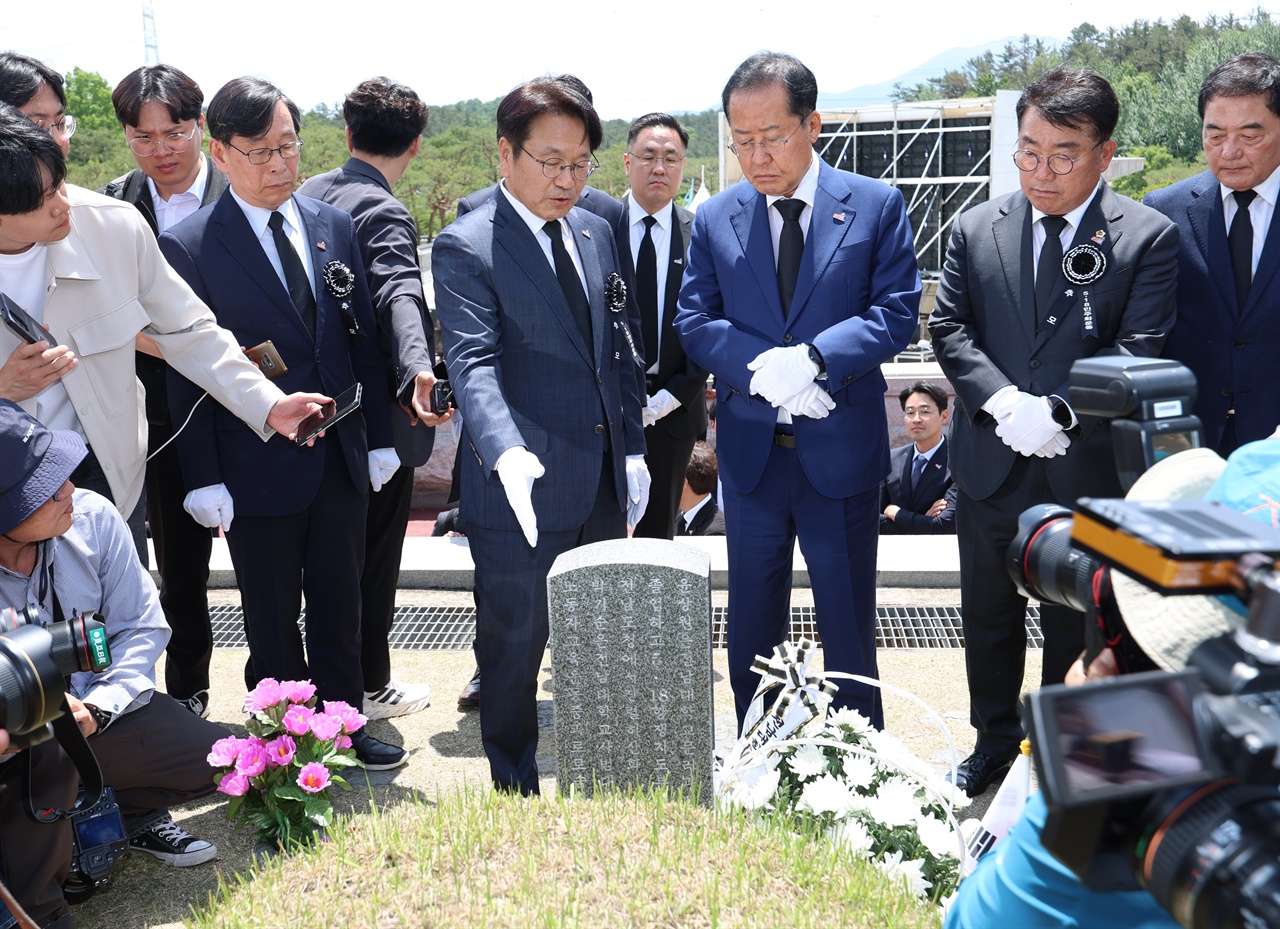  5·18 민주화운동 기념일을 하루 앞둔 17일 광주 북구 국립 5·18 민주묘지에서 홍준표 대구시장이 윤상원 열사 묘소를 참배한 뒤 강기정 광주시장에게 사연을 듣고 있다. 2024.5.17