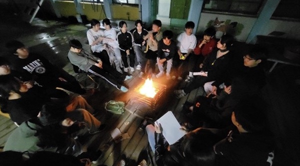 열린주간 마지막 날 밤, 학생들이 학교에서 캠프파이어를 하고 있다.