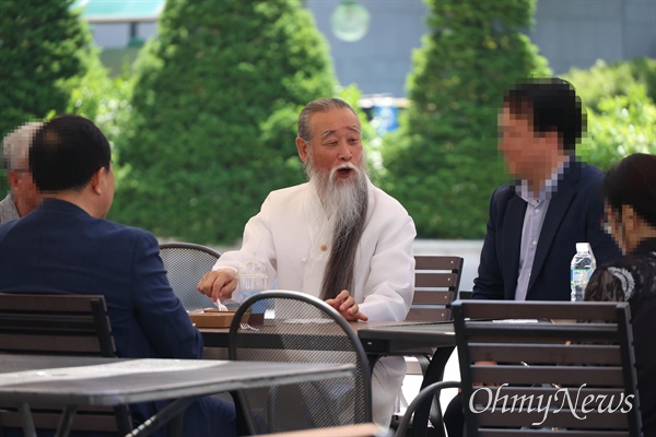 역술인 천공(본명 이천공)이 21일 오후 서울 광화문광장 부근에서 일행들과 함께 커피를 마시며 이야기를 나누고 있다.