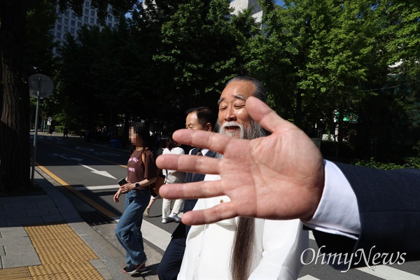 역술인 천공(본명 이천공)이 21일 오후 서울 광화문역 구내 한 도자기 전시장을 방문한 뒤 나오고 있다. 한 수행원이 촬영을 제지하며 손으로 가리고 있다.