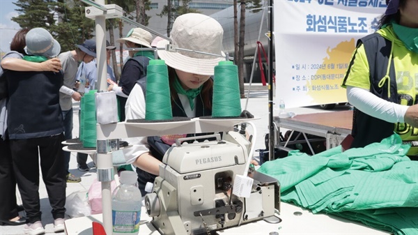 서울봉제인지회 조합원이 재봉틀로 결의대회 참가자들에게 나눠줄 손수건을 제작하고 있다. 
