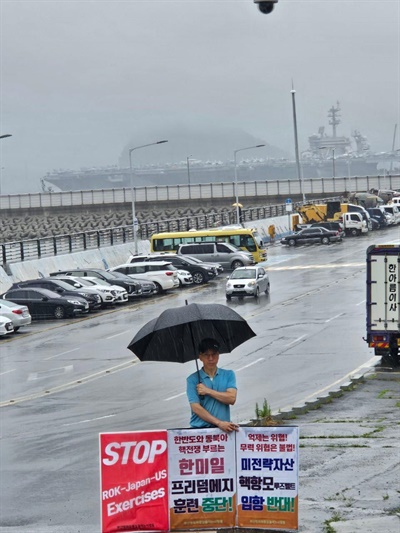 폭우 속에서 루즈벨트 핵 항모 입항을 규탄하는 1인시위를 진행하는 신차범 부산평통사 운영위원.